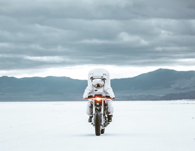 白天雪地上的白色摩托车
